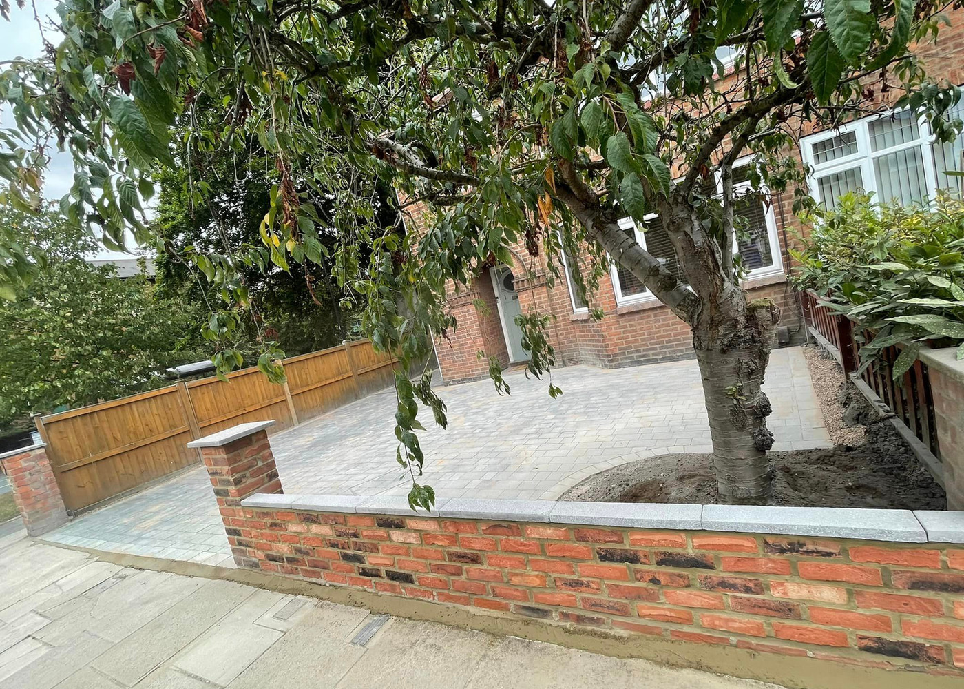 Block paved driveway with brick retaining wall and granite coping in York